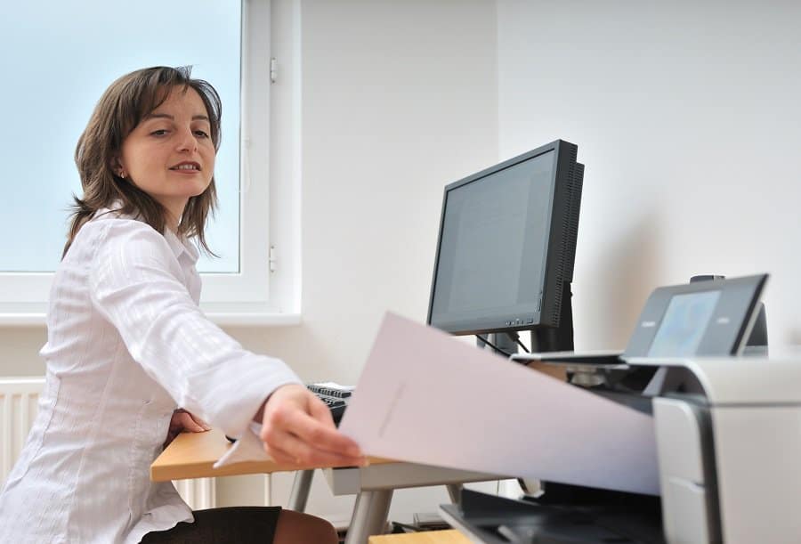 businesswoman using a printer and laptop