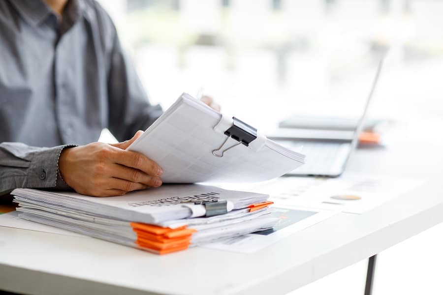 man with files of paper