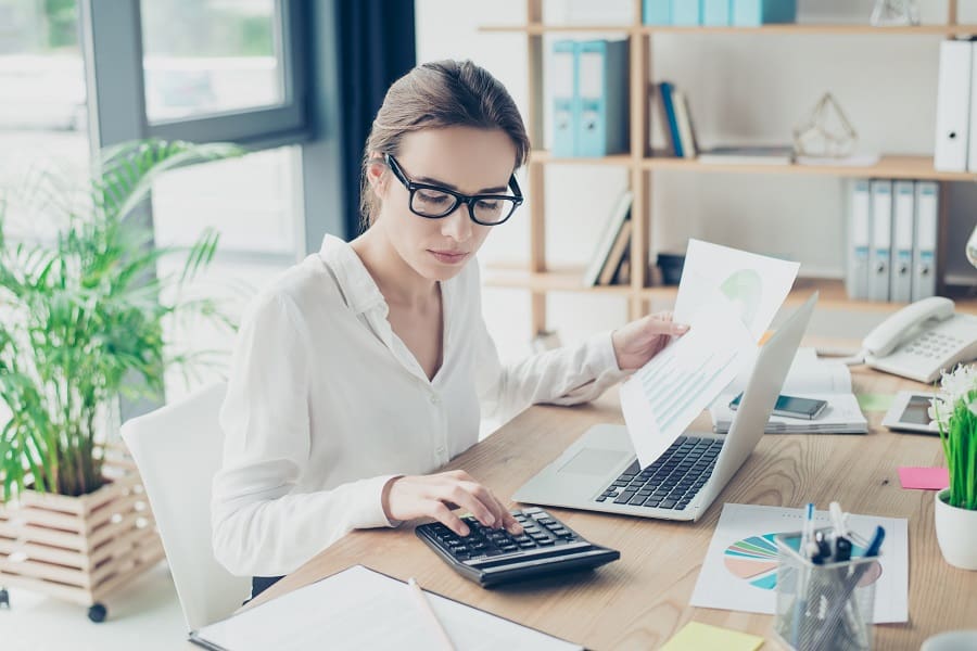 young accountant working on laptop and calculator